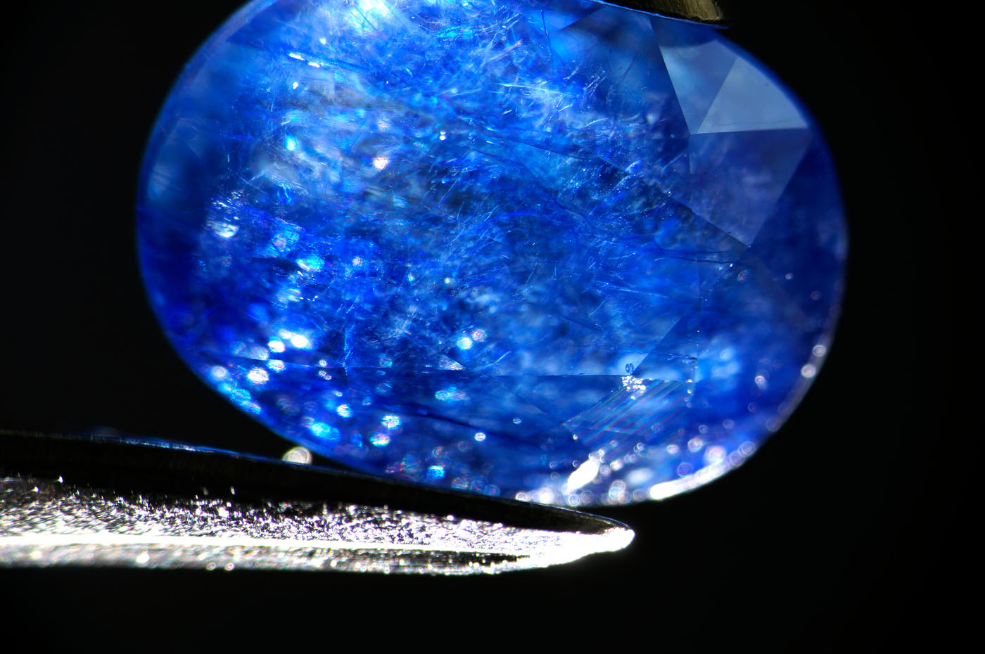 Figure 7. At low magnification the new generation stones display a roiled appearance caused by the network of glass-filled fissures. Dark-field illumination. (Photo: Wimon Manorotkul, Lotus Gemology).