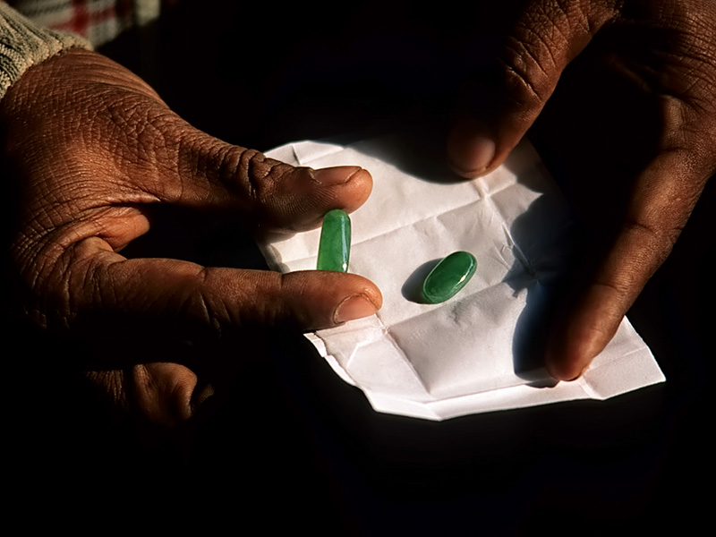 Jade on offer at Mandalay's open air jade market. Much of the material is treated or imitation. The stones shown here are white jade coated with green plastic. 